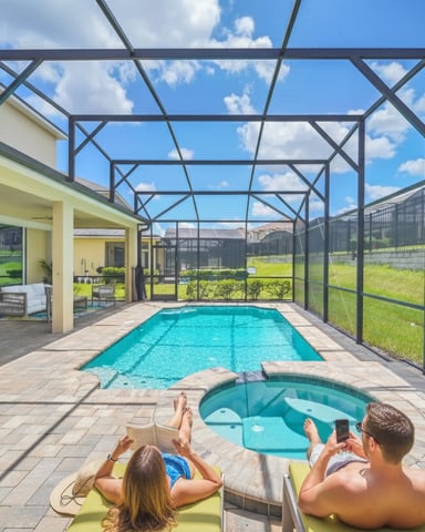 Casa térrea com exterior cinza, garagem para dois carros e família caminhando em direção à entrada ao pôr do sol